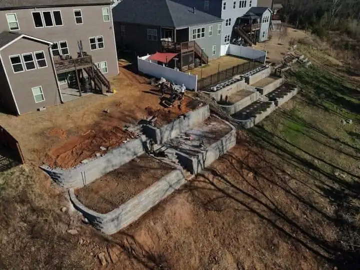 Retaining walls under construction in a sloping backyard.